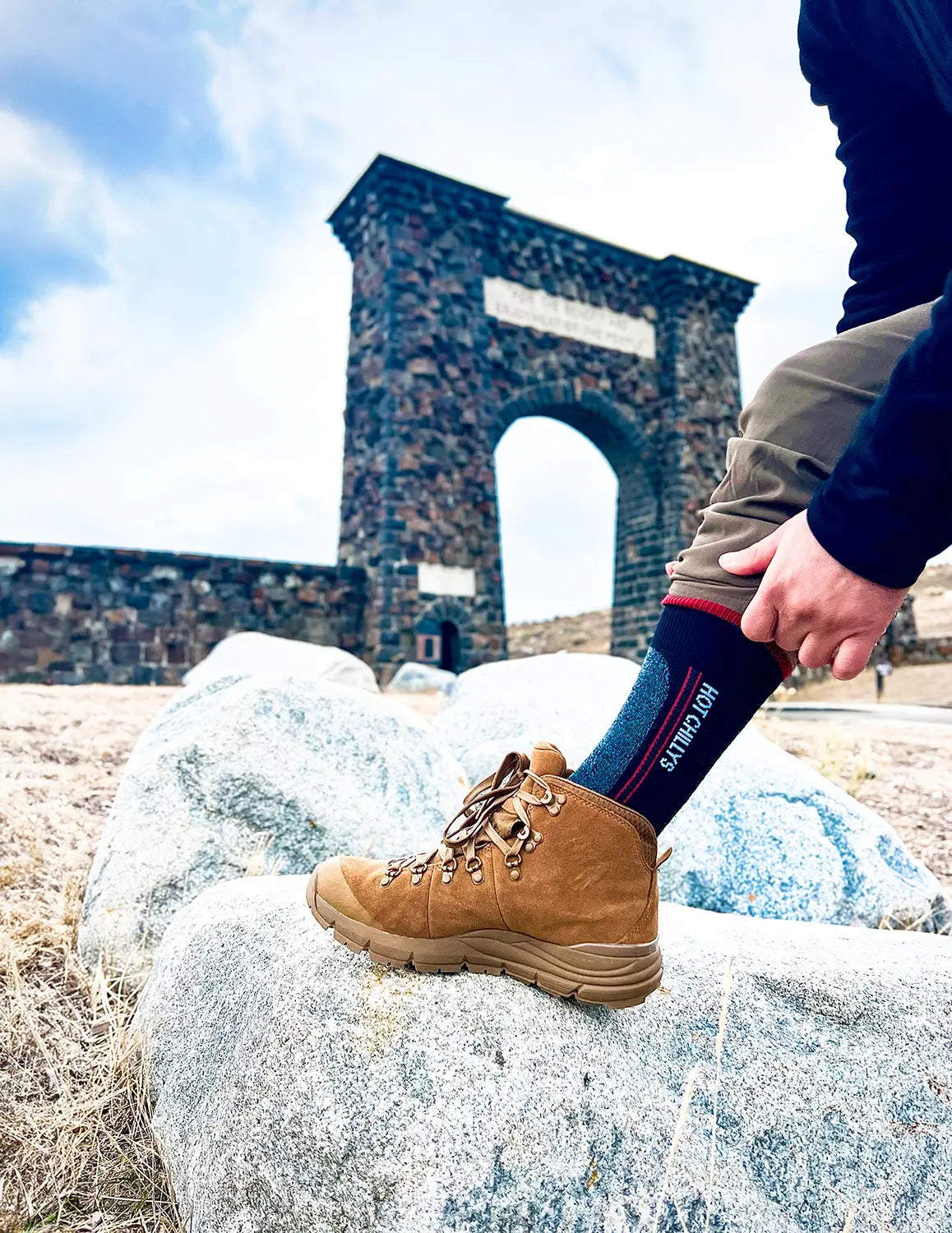 Hiker wearing Hot Chillys Elite Heat socks at Yellowstone National Park entrance